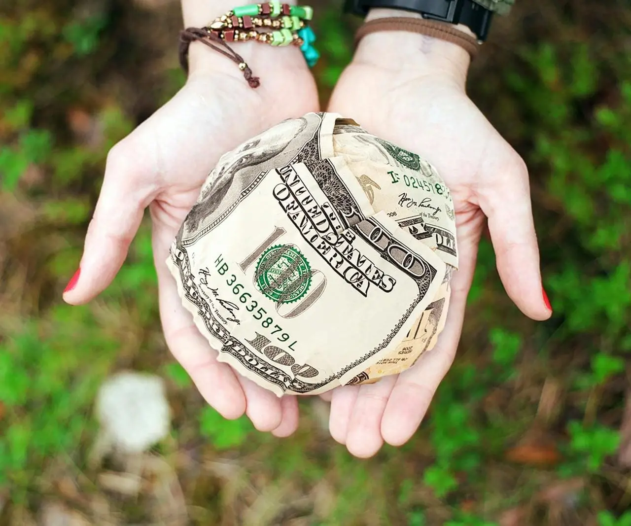 herencia en vida o donacion, aparecen unas manos, con una bola de billetes