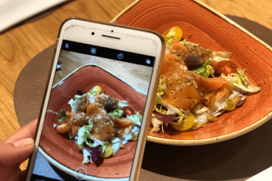 Persona haciendo una foto a un plato de comida con un smartphone
