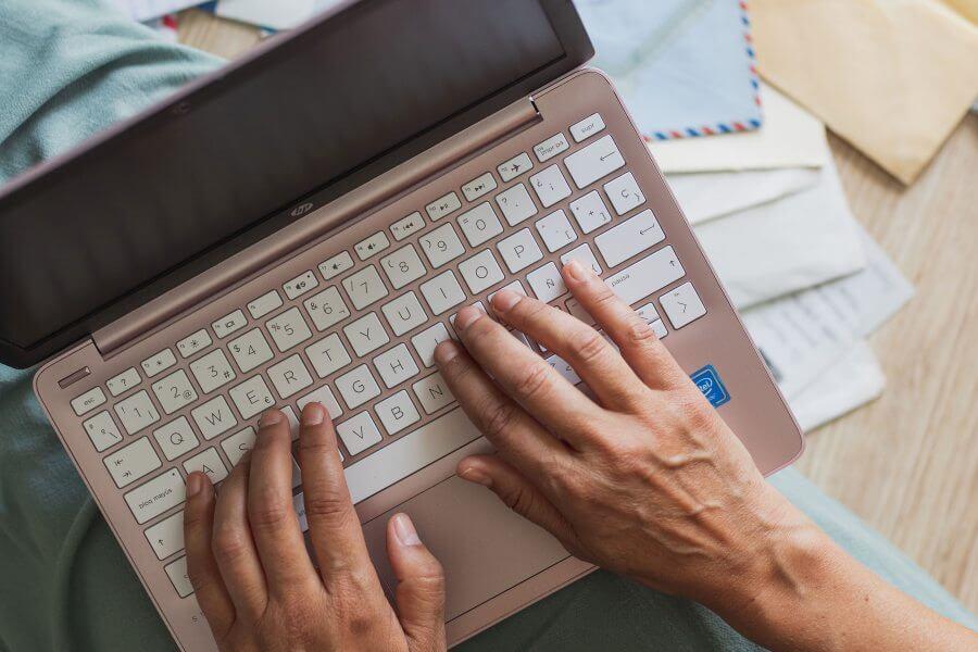 Escritor tecleando en su portátil. Servicios editoriales a medida.
