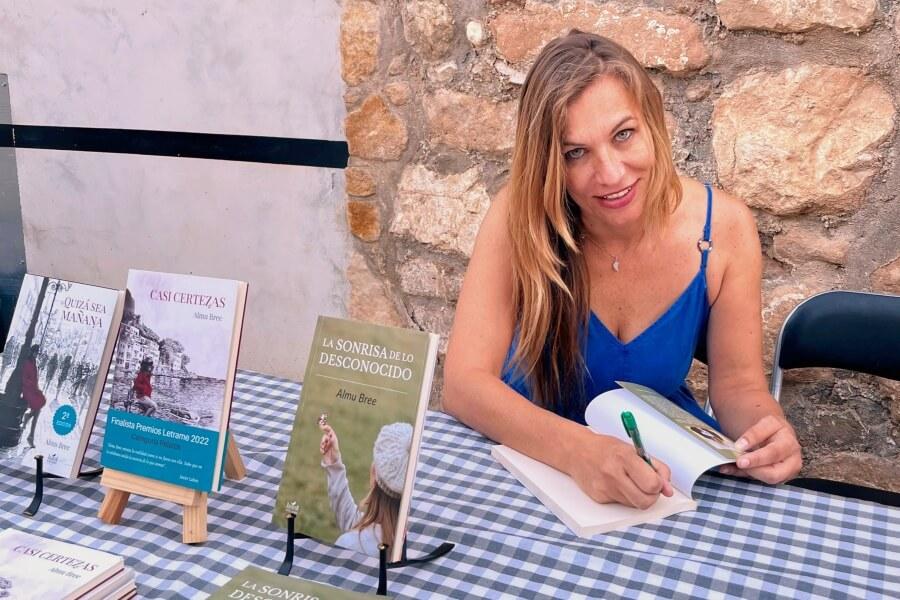 La escritora Almu Bree firmando ejemplares de su libro "La sonrisa de lo desconocido"