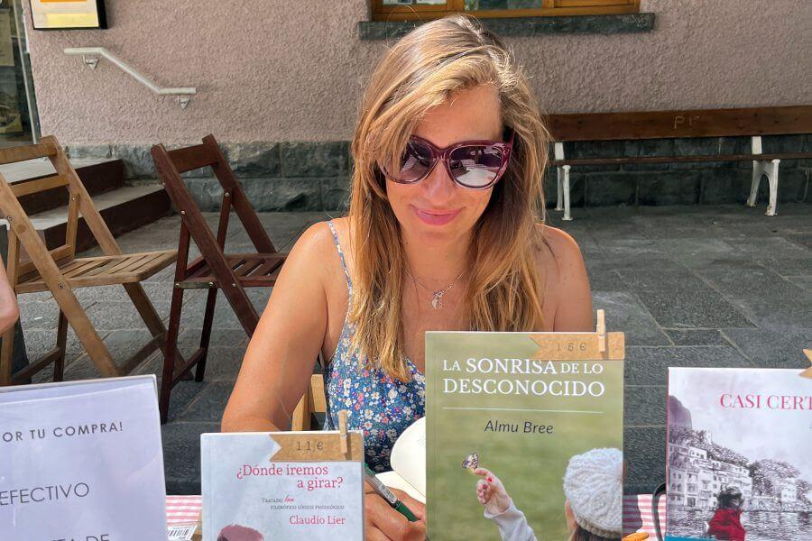 La escritora Almu Bree firmando ejemplares de su novela La sonrisa de lo desconocido en la Feria del Libro de Canfranc